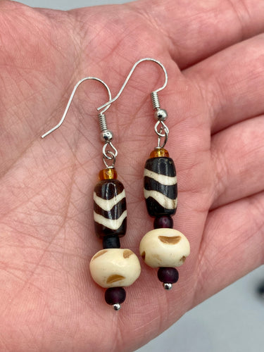Featuring a classic wavy line design, these earring sets come in a neutral color palette, making them suitable for a wide range of occasions. Creatively crafted from both cylinder and round bone beads, they offer a distinct, eye-catching look that will surely make your ensemble stand out.  Measurements: 1 1/2 ” in length  
