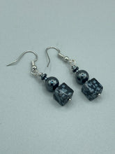 Load image into Gallery viewer, These earrings feature large square shape snowflake obsidian beads complemented with round hematite beads. The neutral cool tones of the stone beads create a unique and versatile style. Measurements: 1 1/4” in length

