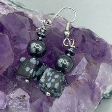 Load image into Gallery viewer, These earrings feature large square shape snowflake obsidian beads complemented with round hematite beads. The neutral cool tones of the stone beads create a unique and versatile style. Measurements: 1 1/4” in length
