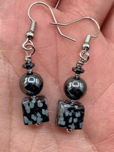 Load image into Gallery viewer, These earrings feature large square shape snowflake obsidian beads complemented with round hematite beads. The neutral cool tones of the stone beads create a unique and versatile style. Measurements: 1 1/4” in length
