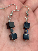 Load image into Gallery viewer, This pair of earrings features two large square-shaped black obsidian beads and small square-shaped hematite beads. With its distinct yet versatile look, this item is sure to make a statement. Measurements: 1” in length

