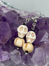 Load image into Gallery viewer, These handcrafted Mini Howlite Skull Bead and Bone Carved Bead Earrings will give any goth, emo, or witchy outfit an extra special touch. Perfect for Day of the Dead celebrations or any casual occasion, these unique earrings will make any look stand out.  Measurements: 1 1/4 ” in length  
