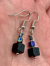 Load image into Gallery viewer, These eye-catching earrings feature a unique combination of large square-shaped black obsidian beads and two small square hematite beads, drawing inspiration from nature to give you a bohemian, hippie vibe. Perfect for a shabby chic, boho chic look. Measurements: 1” in length
