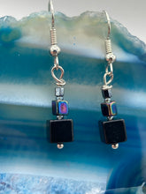 Load image into Gallery viewer, These eye-catching earrings feature a unique combination of large square-shaped black obsidian beads and two small square hematite beads, drawing inspiration from nature to give you a bohemian, hippie vibe. Perfect for a shabby chic, boho chic look. Measurements: 1” in length

