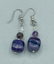 Load image into Gallery viewer, This luxurious set of earrings feature large square-shaped rainbow fluorite beads contrasted against round amethyst beads, presenting an elegant neutral yet cool-toned look. With its unique and versatile style, these earrings make a perfect addition to any wardrobe.  Measurements: 1 3/8” in length

