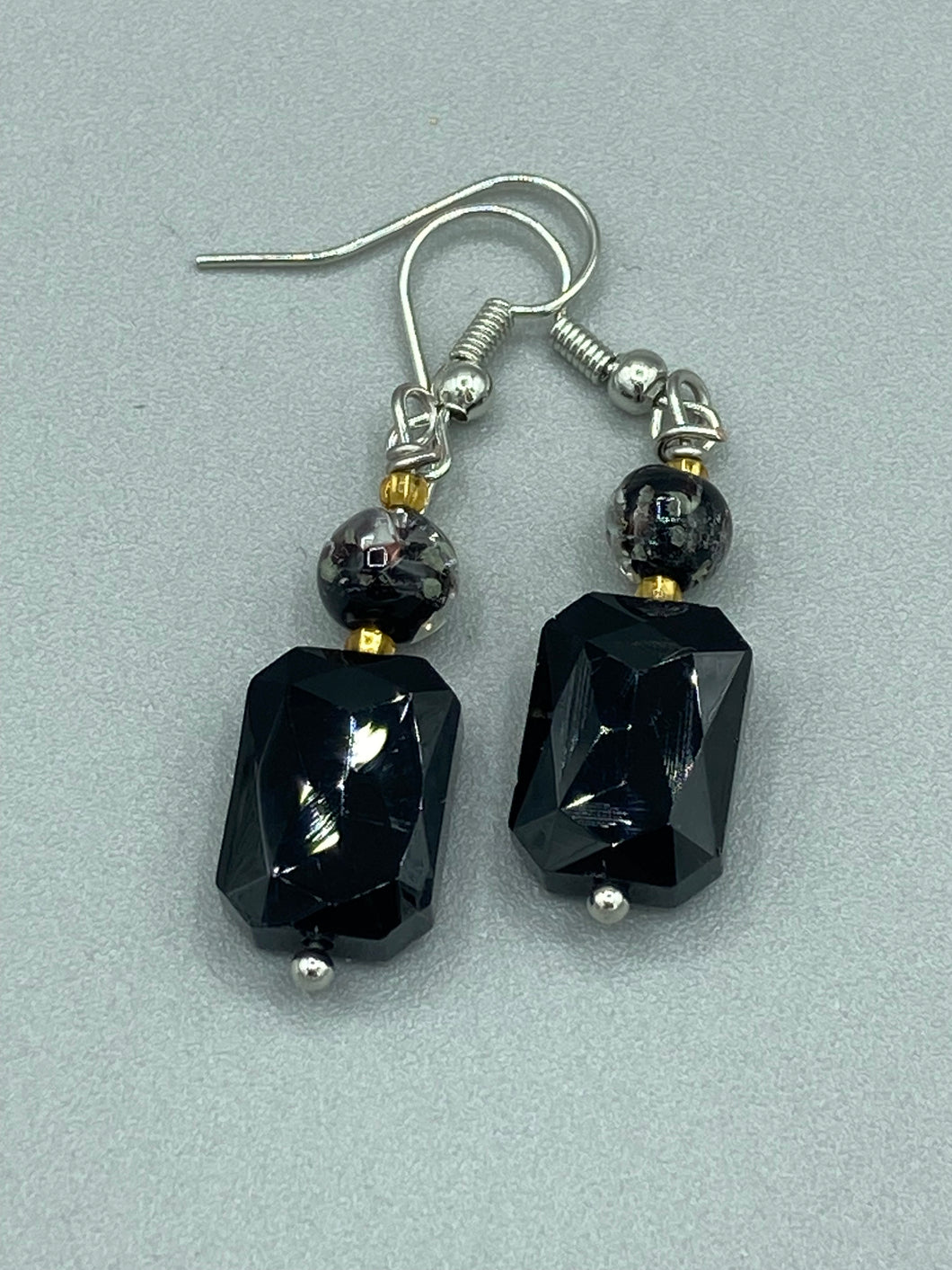Elegantly crafted from black rectangular and circular glass beads, these dainty earrings offer a versatile style that can effortlessly elevate any ensemble.  Measurements: 1 3/8” in length