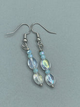 Load image into Gallery viewer, Elevate your style with these simple yet dainty beaded earrings boasting a gentle iridescent and frosty light blue hue. Perfectly versatile, they will add a refined touch to any outfit.  Measurements: 1 1/4” in length

