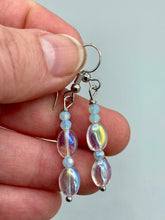 Load image into Gallery viewer, Elevate your style with these simple yet dainty beaded earrings boasting a gentle iridescent and frosty light blue hue. Perfectly versatile, they will add a refined touch to any outfit.  Measurements: 1 1/4” in length
