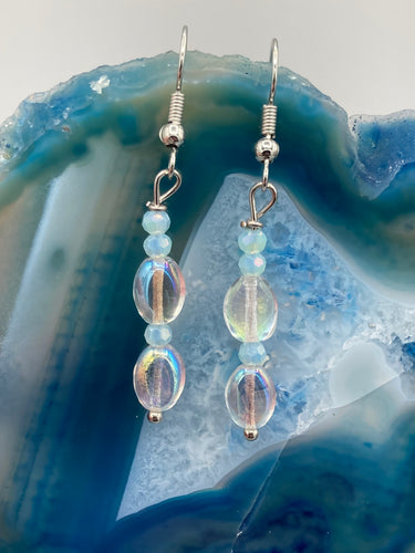 Elevate your style with these simple yet dainty beaded earrings boasting a gentle iridescent and frosty light blue hue. Perfectly versatile, they will add a refined touch to any outfit.  Measurements: 1 1/4” in length