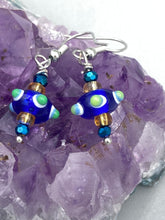 Load image into Gallery viewer, This eye-catching set of earrings features a vibrant color palette of bumpy round lampworked glass beads. The deep cobalt blue, white, light blue, and light yellow fiesta piñata-shaped bead make it truly unique, while the virus-like shape makes it stand out. A bold statement piece, these earrings will surely turn heads. Measurements: 1 1/4” in length 
