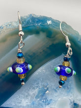 Load image into Gallery viewer, This eye-catching set of earrings features a vibrant color palette of bumpy round lampworked glass beads. The deep cobalt blue, white, light blue, and light yellow fiesta piñata-shaped bead make it truly unique, while the virus-like shape makes it stand out. A bold statement piece, these earrings will surely turn heads. Measurements: 1 1/4” in length 
