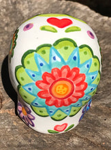 Load image into Gallery viewer, Inspired by nature, this ceramic skull statuette is full of vibrant color and intricate details that I hand painted. The primary color is white with multi-color floral motifs that are painted across the skull, along with hearts and leaves and lively colorful accents around the entire skull. 
