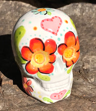 Load image into Gallery viewer, This Mini Floral Ceramic Sugar Skull pays homage to the Dia De Los Muertos tradition. Featuring a vibrant red and yellow flower inspired by a trip to the D.C. Arboretum, this piece of Day Of The Dead Skull Art is a wonderful way to honor those dearly departed. The perfect addition to any home. Measurements: H 2 3/4” x W 2” x D 2”
