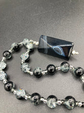 Load image into Gallery viewer, This black agate natural stone necklace features a unique rectangular pyramid shape and multi-colored glass beads. Perfect for all kinds of looks, from cocktail attire to shabby chic to elegant goth styles, this necklace is as versatile as it is stylish and will complete any outfit. The set includes matching earrings, making it a must-have addition to any jewelry collection.  Measurements:  Necklace is 18 1/2” 
