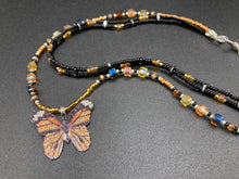 Load image into Gallery viewer, Sterling silver butterfly pendant is molded from a basil leaf and is painted in strikingly bright orange and black.  The first two strands contain two-hole black and silver beads to retain a more &quot;collar&quot; shape. They are primarily black beads with larger orange beads. The third and slightly longer strand has bright gold and orange square shaped glass beads along the black beads to compliment the monarch butterfly wings. Perfect for your summer look! Necklace is 14” adjustable up to 18&quot; - pendant is 1” 

