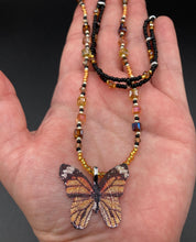Load image into Gallery viewer, Sterling silver butterfly pendant is molded from a basil leaf and is painted in strikingly bright orange and black.  The first two strands contain two-hole black and silver beads to retain a more &quot;collar&quot; shape. They are primarily black beads with larger orange beads. The third and slightly longer strand has bright gold and orange square shaped glass beads along the black beads to compliment the monarch butterfly wings. Perfect for your summer look! Necklace is 14” adjustable up to 18&quot; - pendant is 1” 
