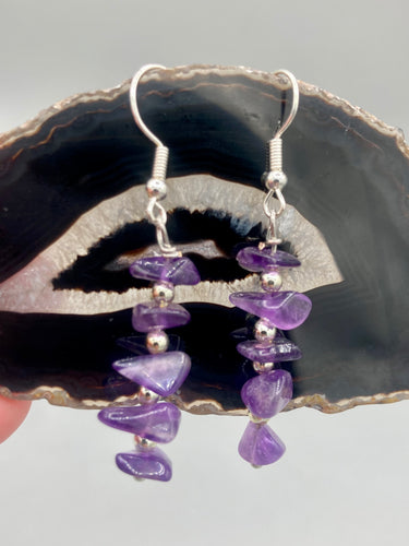 This single strand of beads is composed of natural amethyst stone chips and silver glass beads for a unique, bohemian look. Measurements: 1 1/2 ” in length 