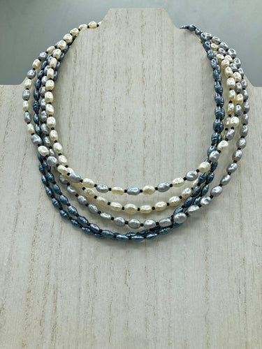 This necklace boasts five strands of varying shades of white and gray faux baroque pearls, as well as a selection of black glass beads. Measurements:   Necklace is 16 1/2