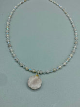 Load image into Gallery viewer, This elegant necklace is adorned with a beautiful rose quartz pendant featuring an intricate floral cutout, complemented by small round rose quartz beads with an iridescent glass finish.  Measurements:  Necklace is 18 1/2”
