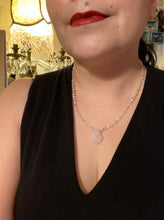 Load image into Gallery viewer, This elegant necklace is adorned with a beautiful rose quartz pendant featuring an intricate floral cutout, complemented by small round rose quartz beads with an iridescent glass finish.  Measurements:  Necklace is 18 1/2”
