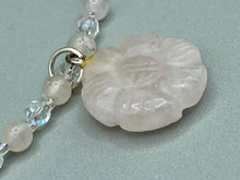 Load image into Gallery viewer, This elegant necklace is adorned with a beautiful rose quartz pendant featuring an intricate floral cutout, complemented by small round rose quartz beads with an iridescent glass finish.  Measurements:  Necklace is 18 1/2”
