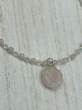Load image into Gallery viewer, This elegant necklace is adorned with a beautiful rose quartz pendant featuring an intricate floral cutout, complemented by small round rose quartz beads with an iridescent glass finish.  Measurements:  Necklace is 18 1/2”
