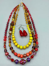 Load image into Gallery viewer, This eye-catching piece set of earrings consists of large fire engine red and tiny teal glass beads for a vibrant and bold look.  Measurements: 1 1/2” in length 
