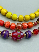 Load image into Gallery viewer, This necklace consists of three strands with a multitude of shades ranging from red to orange, gold, and amber, providing a captivating visual combination. Crafted with a combination of glass, ceramic and metal beads, this eye-catching piece of jewelry radiates power and strength.  Measurements:  Necklace is 16” in length, can be adjusted up to 17 1/2&quot;
