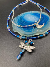 Load image into Gallery viewer, Soft Blue and Silver Adjustable Choker Style Glass Beaded Necklace With A Silver Dragonfly Pendant. Whimsical smiling crescent moon dangling charm comes matching earrings. Dainty elegant summer necklace has the perfect witchy, whimsical, magical, starry night look, it will complete any look.  Measurements: Necklace is 15” adjustable up to 18&quot; in length - pendant is nickel free and 1 1/2” Height
