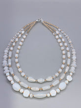 Load image into Gallery viewer, This necklace is the perfect finishing touch to any outfit. Featuring three strands of white and gold glass beads for a classic and elegant look. The small clear and gold glass beads add a touch of sophistication. Adjustable for a comfortable fit.  Measurements:   Necklace is 17” in length, can be adjusted up to 19 1/2" 
