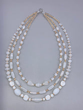 Load image into Gallery viewer, This necklace is the perfect finishing touch to any outfit. Featuring three strands of white and gold glass beads for a classic and elegant look. The small clear and gold glass beads add a touch of sophistication. Adjustable for a comfortable fit.  Measurements:   Necklace is 17” in length, can be adjusted up to 19 1/2" 
