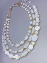 Load image into Gallery viewer, This necklace is the perfect finishing touch to any outfit. Featuring three strands of white and gold glass beads for a classic and elegant look. The small clear and gold glass beads add a touch of sophistication. Adjustable for a comfortable fit.  Measurements:   Necklace is 17” in length, can be adjusted up to 19 1/2" 
