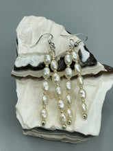 Load image into Gallery viewer, Two long strands of simulated white baroque pearls and silver glass beads come together to create this exquisite accessory.  Measurements: 2” in length 
