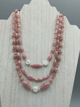 Load image into Gallery viewer, This three-strand beaded necklace is crafted with iridescent dusty rose glass, along with white, gold, pink, and iridescent purple beads for an eclectic mix of colors, tones, and textures. Perfect for any occasion, this gorgeous statement piece will add the finishing touch to your look.   Measurements:   Necklace is 17” in length, can be adjusted up to 19&quot; 
