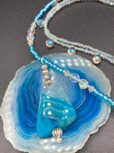 Load image into Gallery viewer, This exquisite necklace features a vibrant Sea Blue Agate Natural Stone Pendant and two strands of multi-colored glass beaded necklace. An adjustable collar-style strand contains small, light blue beads and lots of iridescent double-hole beads for shimmer and sparkle. The longer strand features larger blue glass beads interspersed with clear and silver beads for a sophisticated, draped look. It's finished with a set of dainty matching earrings for a complete look. Necklace is 14”adjustable up to 18"
