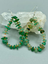 Load image into Gallery viewer, Elegant hoop earrings featuring natural green aventurine stone chips and gold-tinged glass beads. Measurements: 2&quot; length and 1 1/2” in width  
