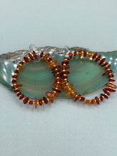 Load image into Gallery viewer, These hoop earrings feature natural amber stone chips and gold glass beads for an elegant, nature-inspired look.  Measurements: 2&quot; length and 2” in width   
