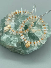 Load image into Gallery viewer, These beautiful white moon stone chip and gold glass beaded hoop earrings feature natural conch shells, perfect for a touch of nature-inspired masterful craftsmanship. A must-have accessory for those with a love of the outdoors, beach, and summertime.   Measurements: 1 3/4" length
