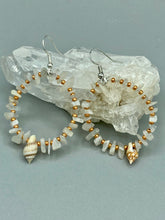 Load image into Gallery viewer, These beautiful white moon stone chip and gold glass beaded hoop earrings feature natural conch shells, perfect for a touch of nature-inspired masterful craftsmanship. A must-have accessory for those with a love of the outdoors, beach, and summertime.   Measurements: 1 3/4" length
