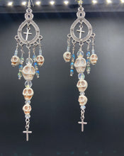 Load image into Gallery viewer, Large Chandelier Style Earrings Howlite Skull Beads Silver Plated Crosses. Ultimate Chingona, Cabrona, Latina Chicana, Goth, Vampire Goth, Dark Witchy Style. You can dress these up or down, it will definitely give your outfit a unique look. Cascade of dangling skulls and crosses have plenty of fun movement.  Measurements: 4” in length
