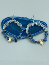Load image into Gallery viewer, These earrings boast a beautiful combination of natural lapis and white moon stone chip stones, artfully inlaid with gold glass beads in a hoop formation. Dainty conch shells add a subtle touch of nature for a look that perfectly captures the beach vibes of summer. An ideal choice to complement any style.  Measurements: 2 1/4&quot; length
