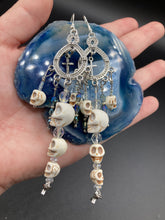 Load image into Gallery viewer, Large Chandelier Style Earrings Howlite Skull Beads Silver Plated Crosses. Ultimate Chingona, Cabrona, Latina Chicana, Goth, Vampire Goth, Dark Witchy Style. You can dress these up or down, it will definitely give your outfit a unique look. Cascade of dangling skulls and crosses have plenty of fun movement.  Measurements: 4” in length
