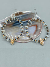 Load image into Gallery viewer, Dainty conch shells and natural white moon stone chips, these dark silver and gold glass beaded hoop earrings are the perfect accessory for any nature-loving, beach-themed outfit. Their versatility allows them to easily complement any outfit.  Measurements: 2 1/4&quot; length
