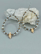 Load image into Gallery viewer, Dainty conch shells and natural white moon stone chips, these dark silver and gold glass beaded hoop earrings are the perfect accessory for any nature-loving, beach-themed outfit. Their versatility allows them to easily complement any outfit.  Measurements: 2 1/4&quot; length
