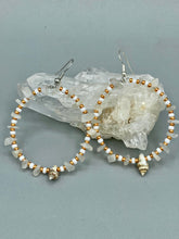 Load image into Gallery viewer, Delicate white moon stone chip and glass beaded hoop earrings featuring chic gold accents and tiny conch shells. Perfect for nature lovers, these boho-inspired summer earrings will add a subtle sophistication to any outfit. Measurements: 2" length
