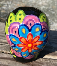 Load image into Gallery viewer, This Mini Day of the Dead Black Ceramic Sugar Skull is a stunning, nature-inspired piece of hand painted art. Featuring elements from a photography I took of a flower floating in a fountain at Grounds for Sculpture, this unique work of art is ideal for honoring memories of those who have passed. Its beautiful mausoleum, statues, and stained glass elements make it the perfect choice for any special occasion. Measurements: H 2 3/4” x W 2” x D 2”
