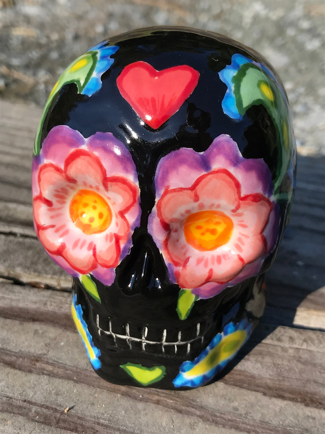 This hand-painted ceramic skull art is an homage to the traditional Mexican Day of the Dead. The inspiration for the skull's exquisite detail was taken from a beautiful flower photographed at the United States Botanic Garden - a whimsical surprise of small flowers floating in water. Bring La Muerte Calavera de Ofrenda, or 'skull of offering', into your home for a captivating reminder of Mexican tradition. H 2 3/4” x W 2” x D 2”