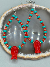 Load image into Gallery viewer, This eye-catching pair of earrings features vibrant fire engine red fish glass beads, accented with small teal, red, and golden glass beads. Each fish bead boasts detailed fins and eyes, creating a bright and captivating piece of jewelry measuring 2" in length.
