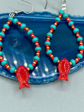 Load image into Gallery viewer, This eye-catching pair of earrings features vibrant fire engine red fish glass beads, accented with small teal, red, and golden glass beads. Each fish bead boasts detailed fins and eyes, creating a bright and captivating piece of jewelry measuring 2" in length.
