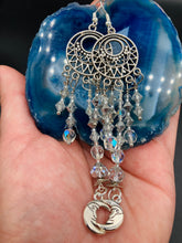 Load image into Gallery viewer, Whimsical Celestial Smiling Crescent Moons Large Chandelier Earrings. Five strands of beautiful clear iridescent glass beads and dangling smiling crescent moon charms. This is perfect for any outfit and will surely stand out. Measurements:  4” in length. Witchy, Whimsical, Goth, Luna Lovers, Crescent Smiling Moons

